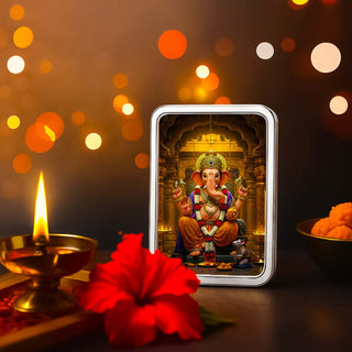 Lord Ganesha silver bar in acrylic case, symbolizing spirituality and elegance with a festive background.